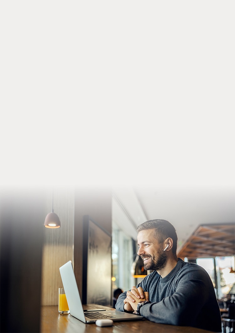 Man laughing while looking at laptop