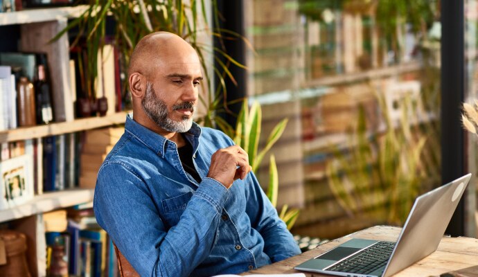 Man sitting at a desk looking at a laptop
